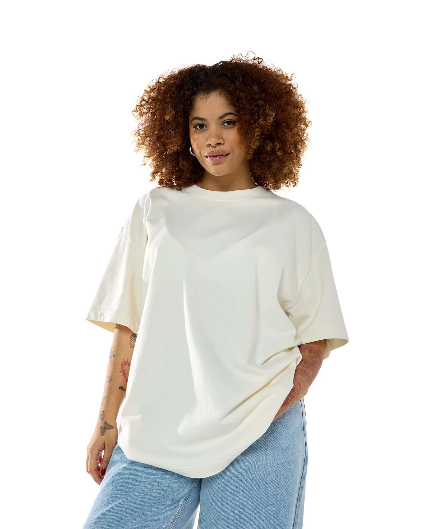 Modelo feminina usando a t-shirt oversized da Kiji na cor off white. Vista de frente