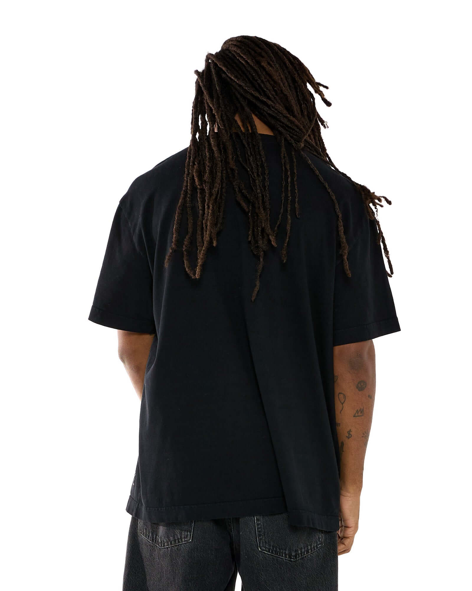 Modelo vestindo a t-shirt oversized na cor preta, vista de costas