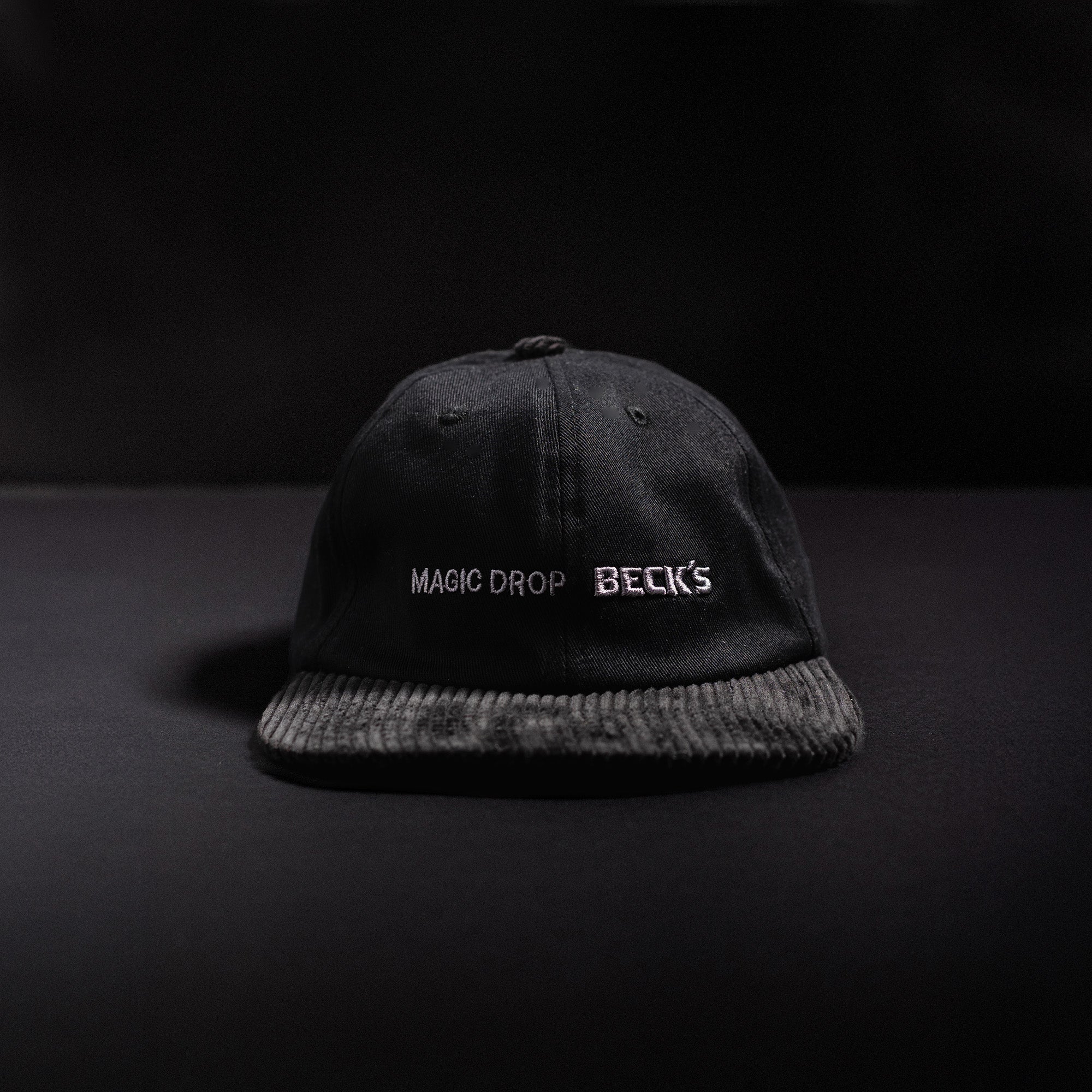 Boné Dad Kiji x Beck's M.D, o boné é preto e possui os dizeres "magic drop"- "Becks" bordado em cinza