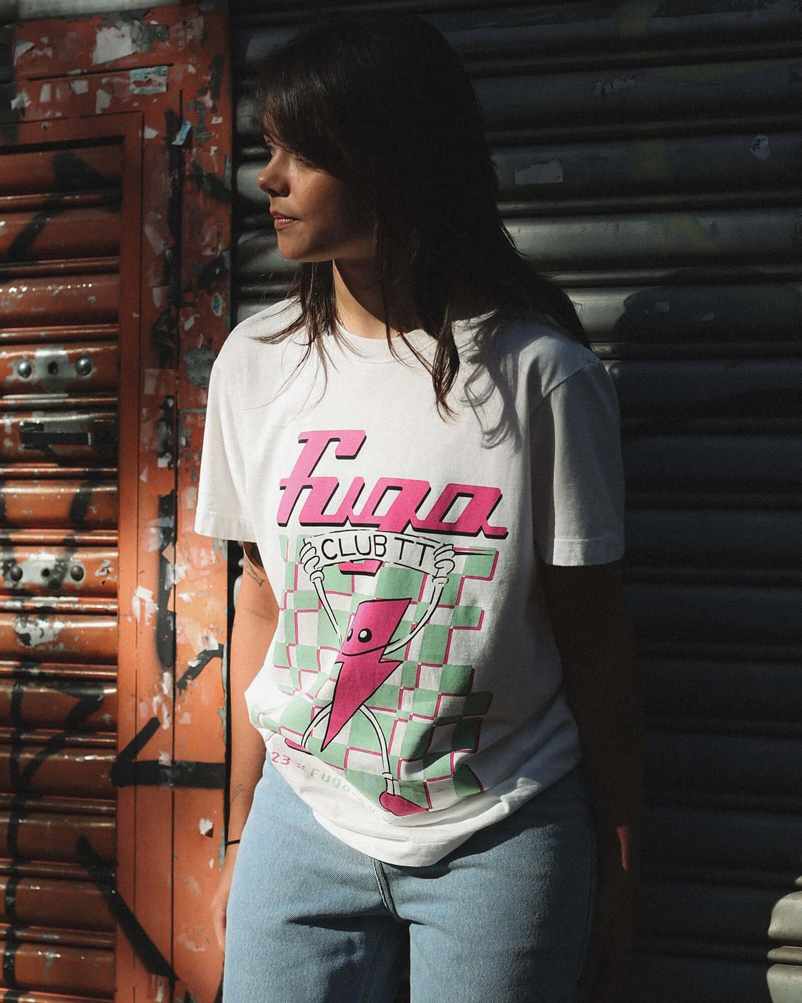 Modelo vestindo a T-Shirt Classic Kiji Off-White TT23 em um ensaio pelas ruas de São Paulo, atrás dela há um portão grafitado