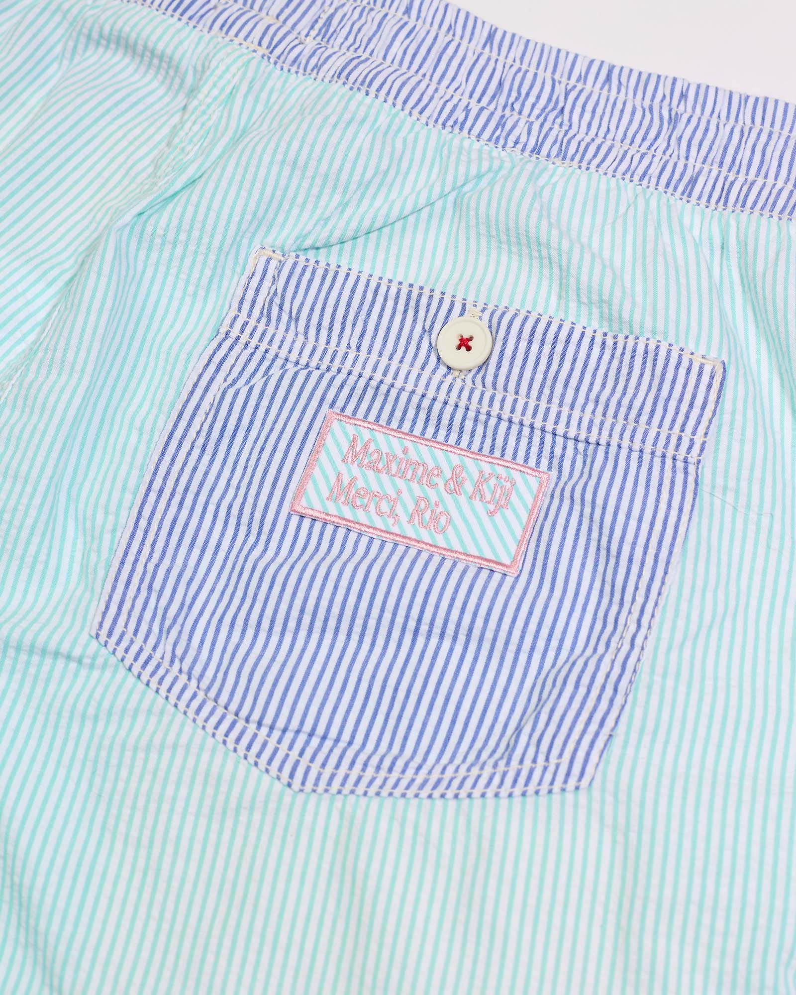 Verso da bermuda Bermuda Stripes Kiji x Maxime Hibisco Verde, mostrando bolso traseiro com detalhes em azul e rosa.