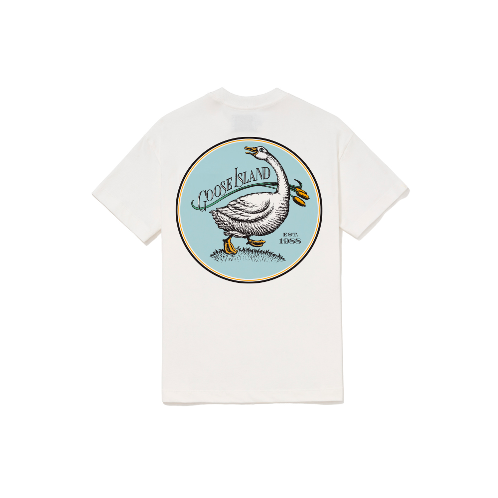 Foto Still da T-Shirt Classic Kiji x Goose Island Off White, a estampa fica nas costas e consiste no logo retrô da marca: um circulo azul com o desenho de um ganso ao centro, na parte superior esquerda do circulo está escrito "Goose Island" e na parte inferior direita "Est. 1988"