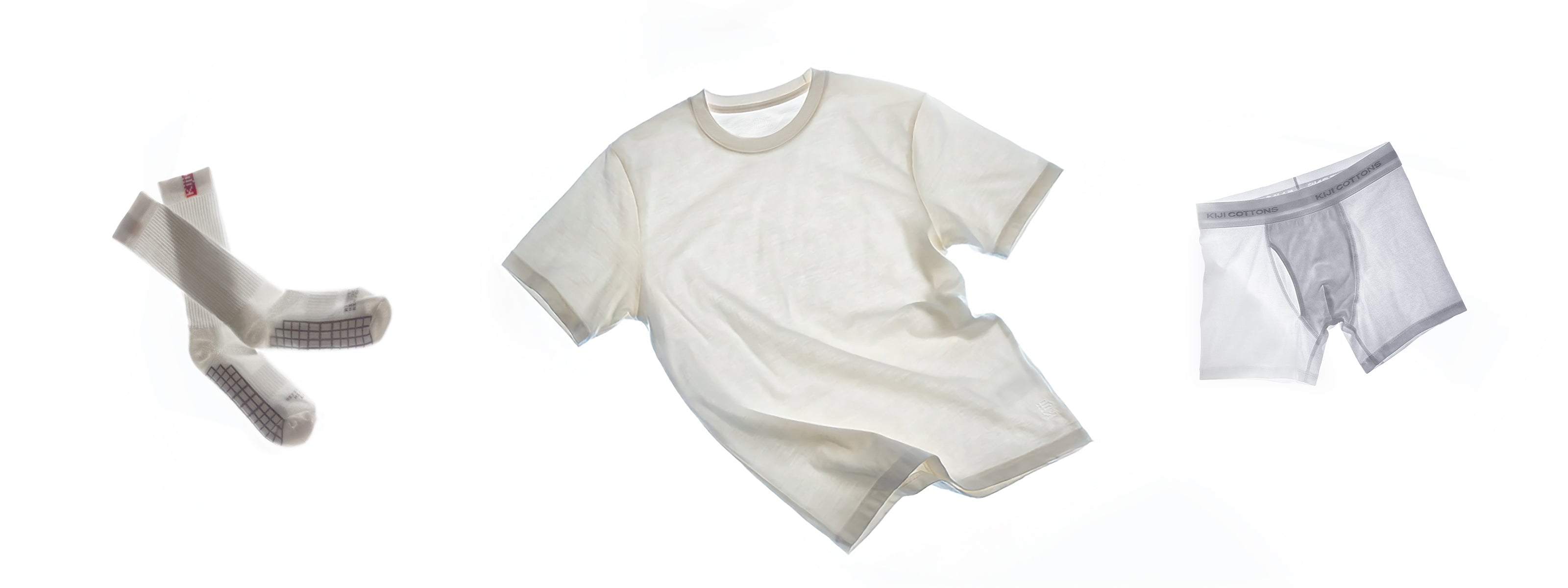 Kiji Combos com camiseta heavy off white, cueca boxer e par de meias, em composição flat lay sobre fundo branco.