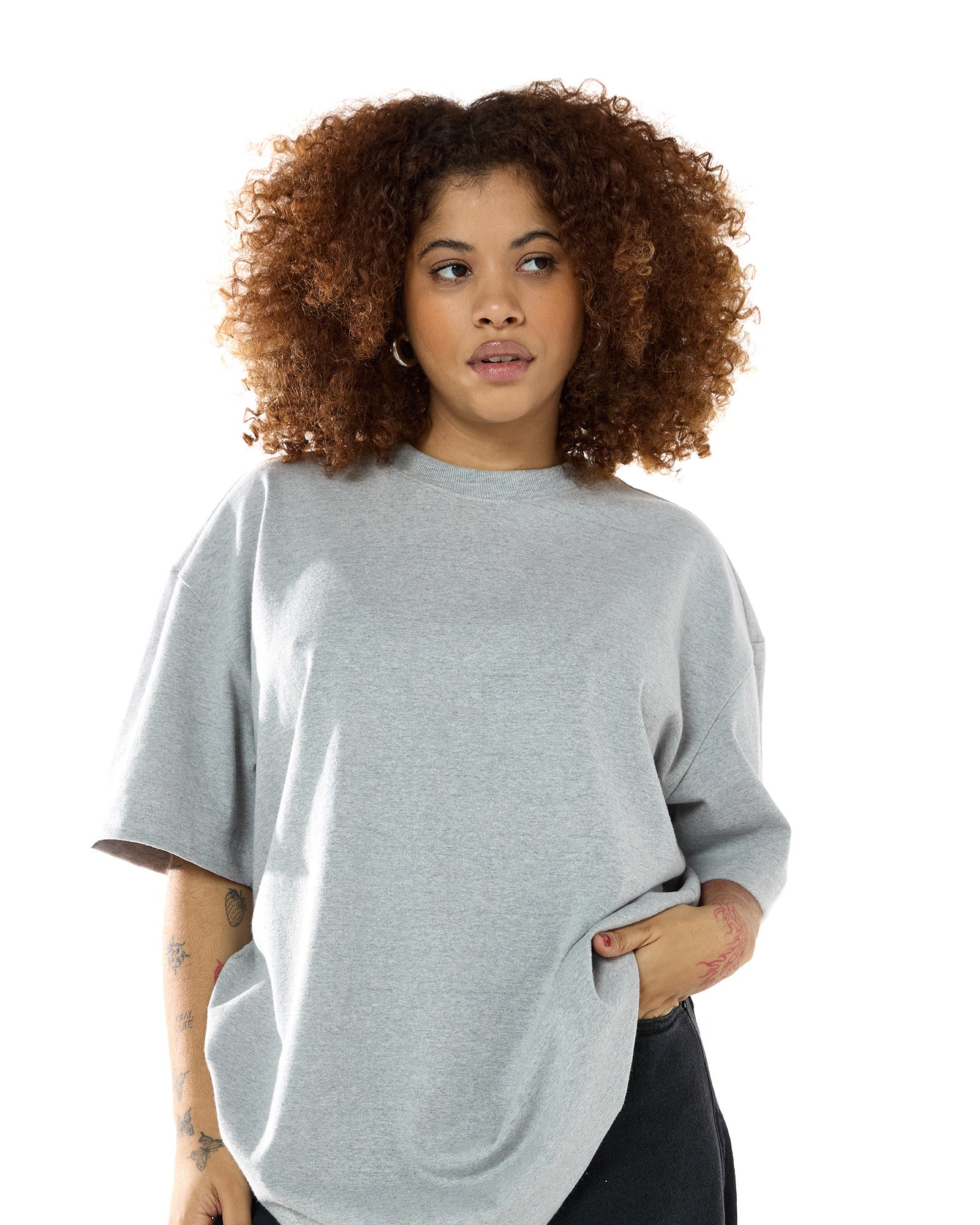 Modelo feminina usando a t-shirt oversized da Kiji na cor cinza mescla. Vista de frente