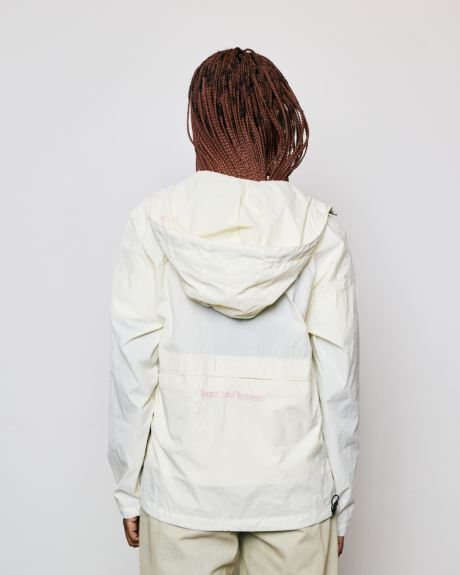 Jaqueta Wind Kiji x Maxime Off White, vista traseira com capuz, detalhes em zíper e tecido leve.