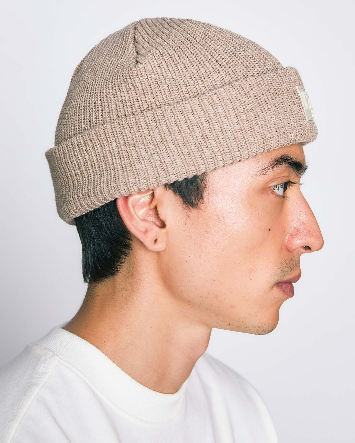 Modelo vestindo Gorro 8bit Kiji de lado, na cor fossil.