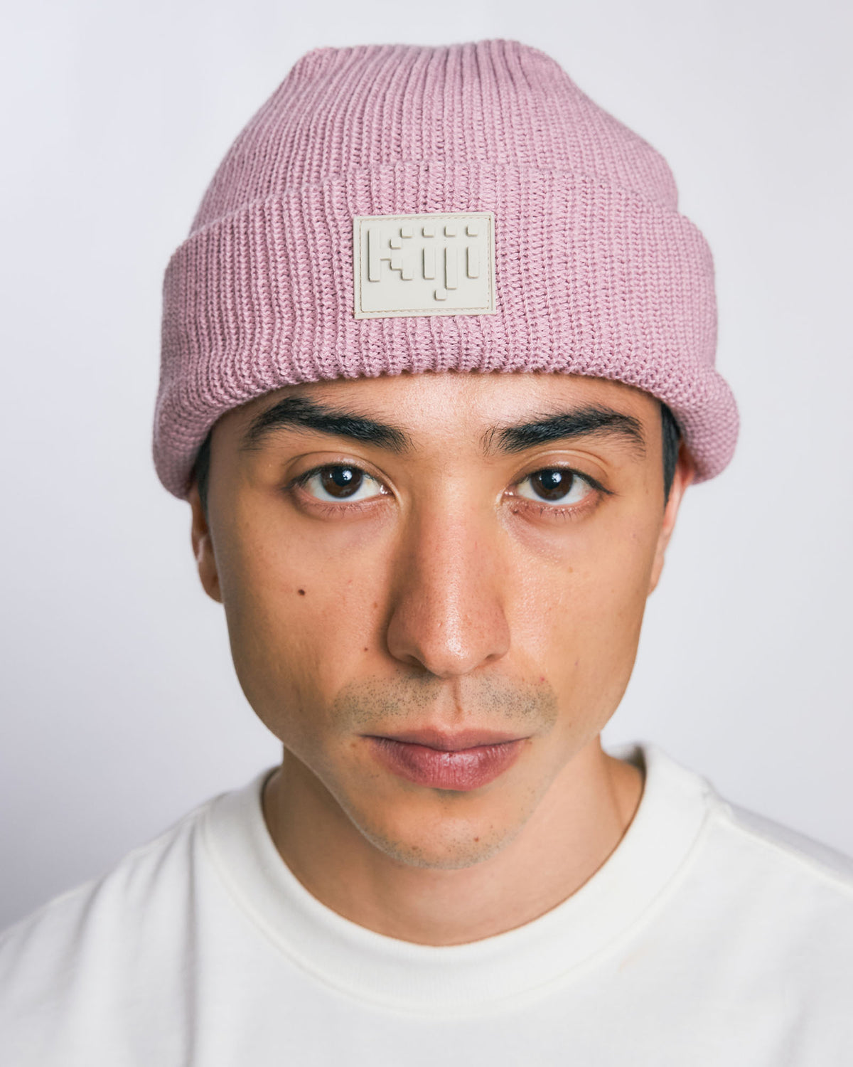 Modelo vestindo Gorro 8bit Kiji de frente, com patch frontal centralizado, na cor rose.