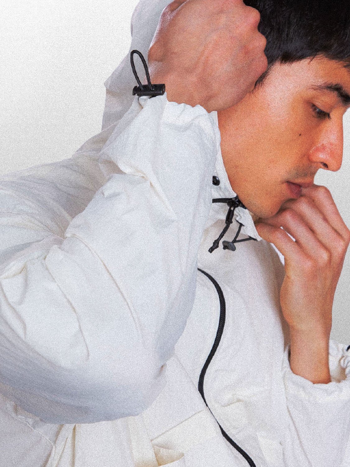 Detalhe do modelo vestido a jaqueta wind Kiji, na visão 3:4, na cor off white.