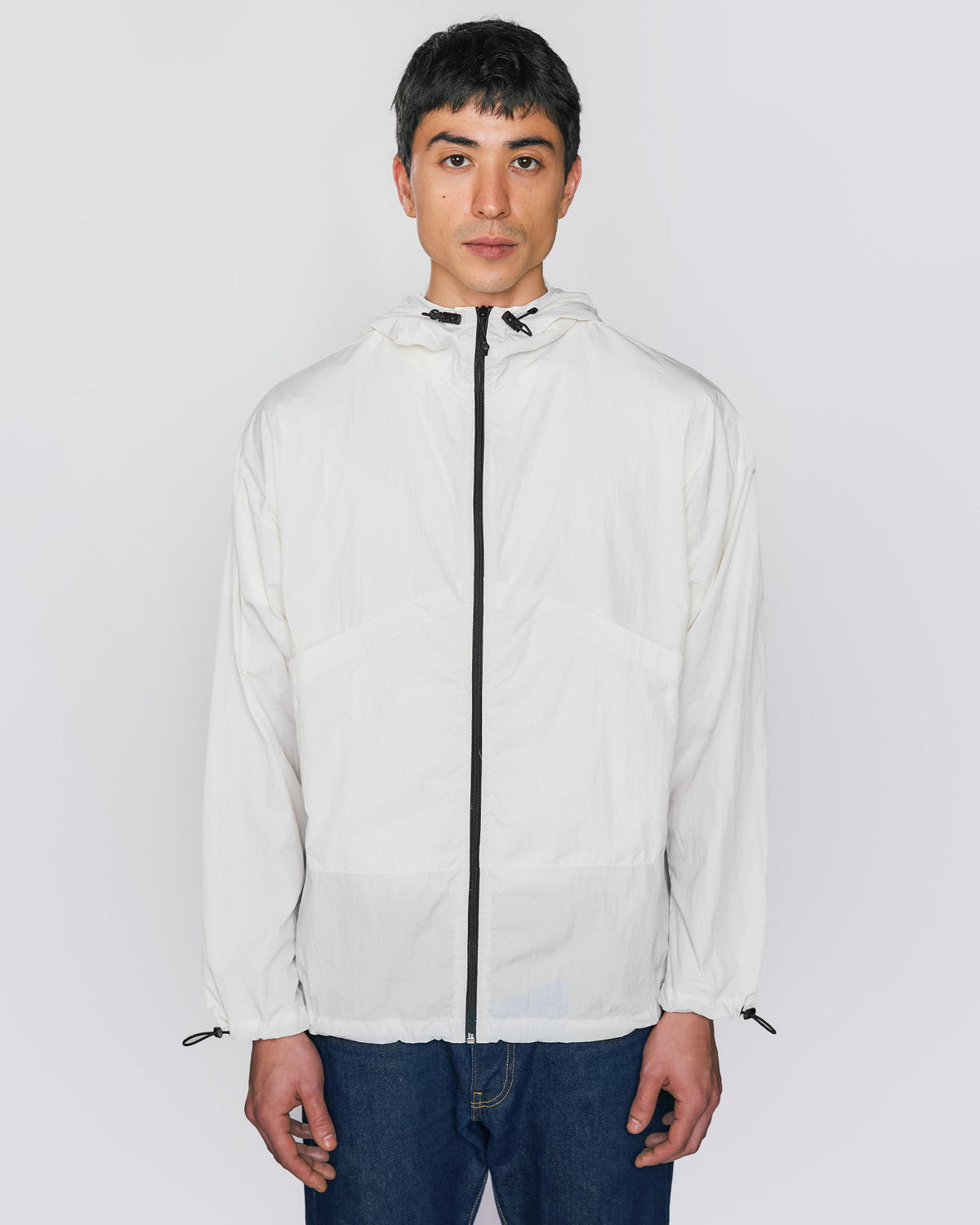 Modelo de frente usando a jaqueta wind Kiji em off white, destacando o fit confortável e moderno.