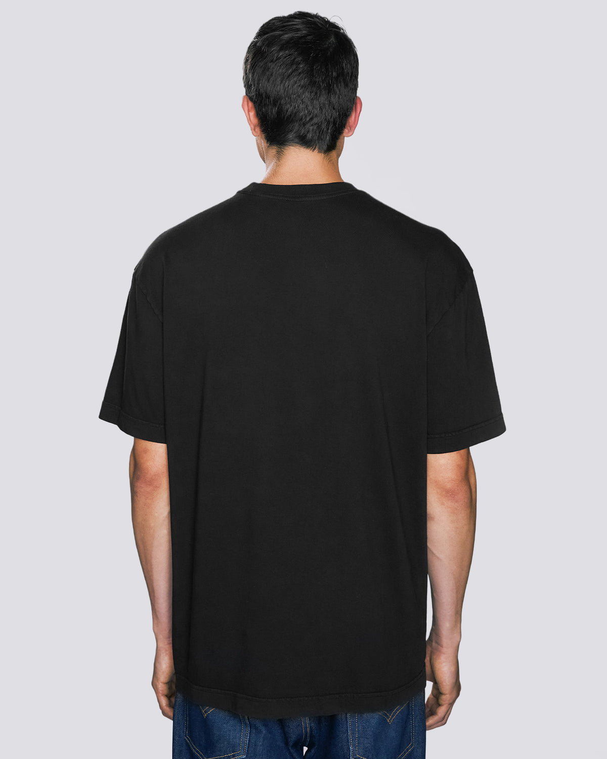 Modelo masculino vestindo a camiseta heavy oversized preto Kiji, vista de costas.
