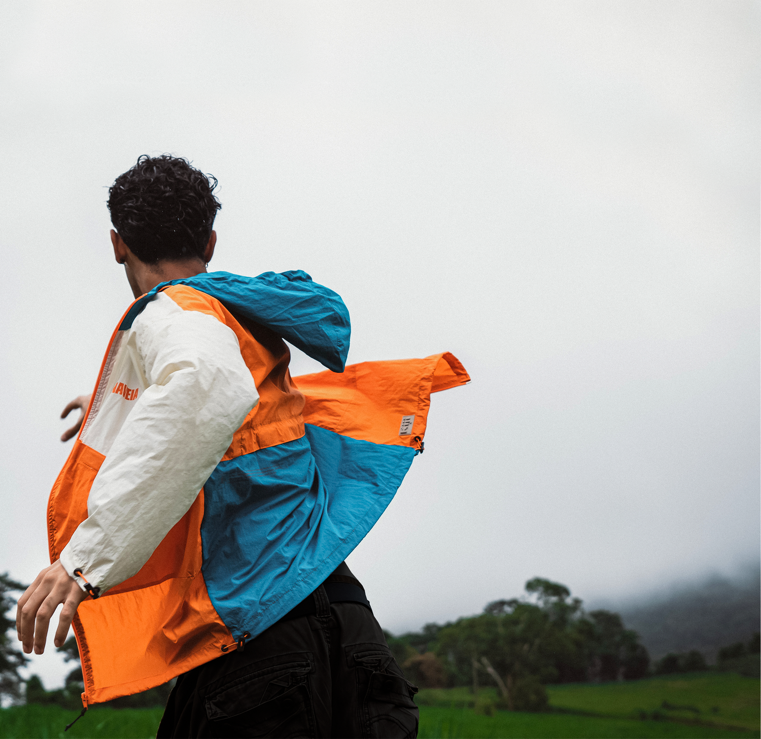 Foto de um homem correndo em um campo aberto enquanto usa a Jaqueta Hiking Kiji x Naveia